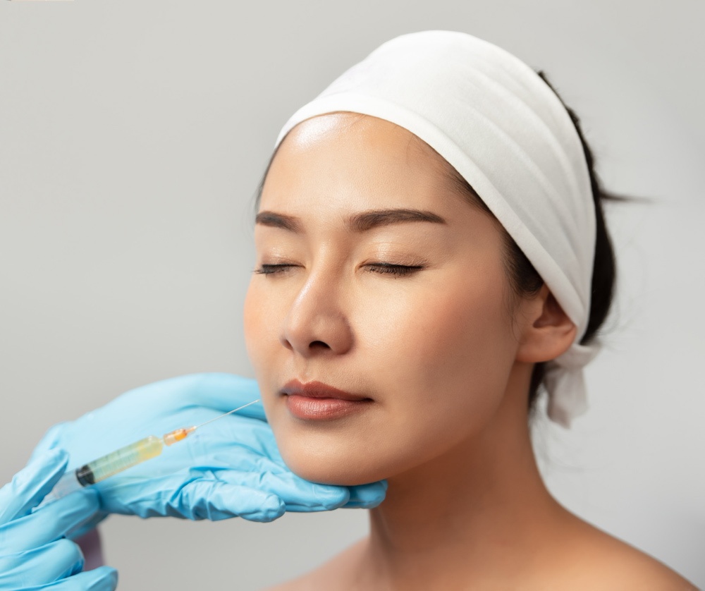 Extreme closeup indoor shot showing lip filler procedure at SPA and wellness salon. A licensed healthcare professional performing dermal filler on her asian female patient. Extreme closeup indoor shot showing lip filler procedure at SPA and wellness salon. A licensed healthcare professional performing dermal filler on her asian female patient.