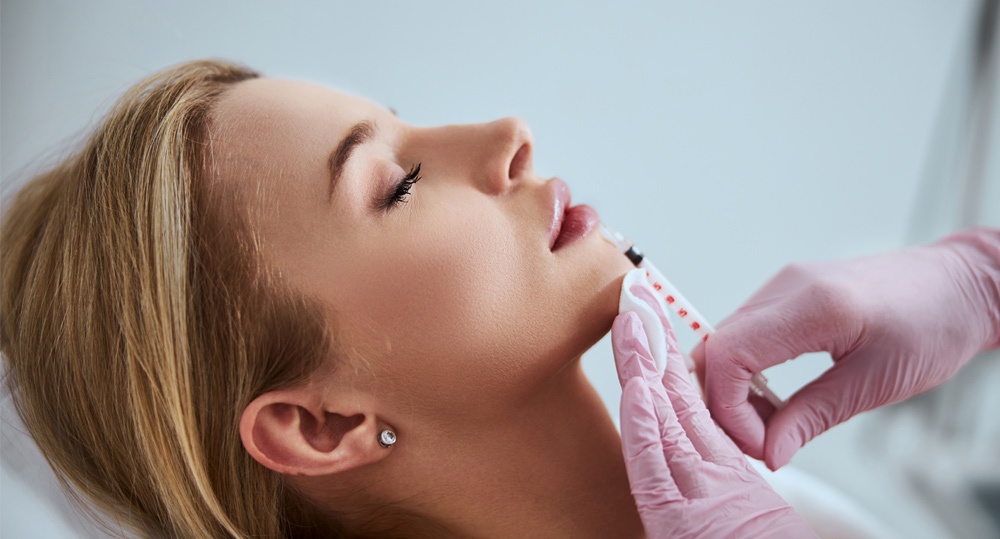 Professional cosmetologist injecting a dermal filler into the patient lips Professional cosmetologist injecting a dermal filler into the patient lips