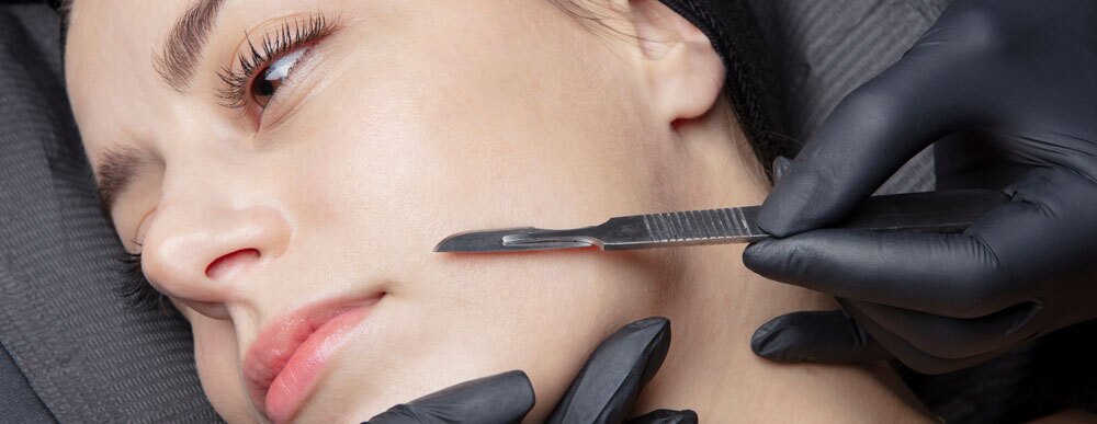 Woman getting dermaplaning facial procedure done on face Woman getting dermaplaning facial procedure done on face