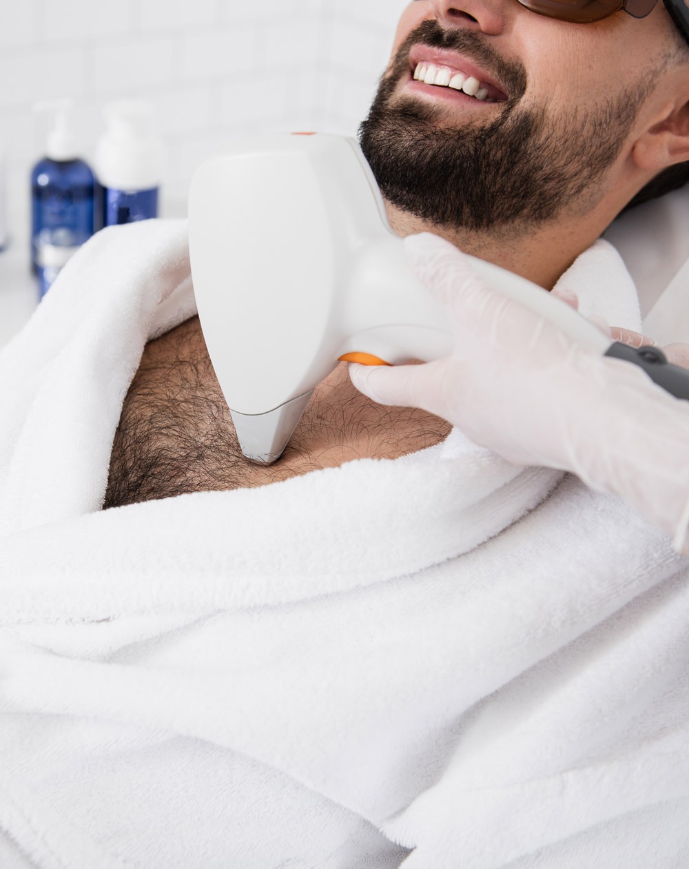 Close up of hand with laser hair removal on hairy male chest Close up of hand with laser hair removal on hairy male chest