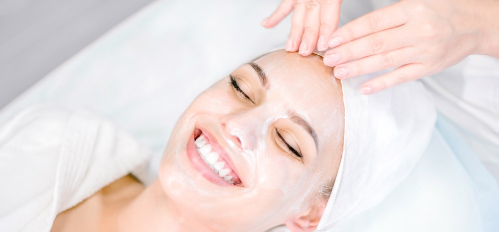 Beautician makes facial massage with mask. Beautiful smiling girl on spa procedure. Facial care. Beautician makes facial massage with mask. Beautiful smiling girl on spa procedure. Facial care.